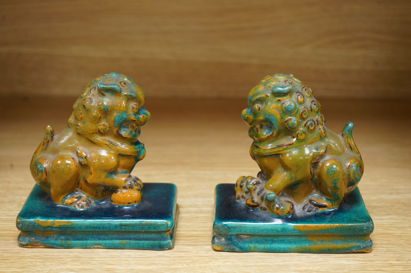 A pair of Chinese turquoise and olive green glazed ceramic lion dogs, Guandong kilns, 19th/20th century, impressed mark, 12cm